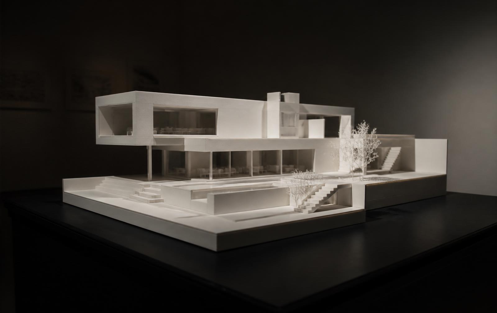 White scale model of the house rising from the plan